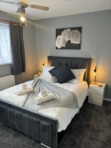 南安普敦Cosy Corner - 2 beds, free parking, garden, 2 mins walk to Southampton General Hospital的一间卧室配有一张大床和毛巾