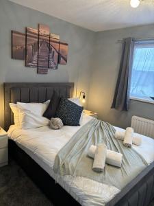 南安普敦Cosy Corner - 2 beds, free parking, garden, 2 mins walk to Southampton General Hospital的一间卧室配有一张床,上面有两条毛巾