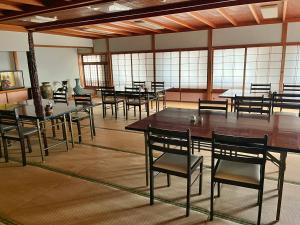 生驹Kanko Ryokan Yamato的大型客房设有桌椅和窗户。