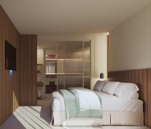 萨洛尤罗萨鲁水疗酒店的卧室配有白色的床和电视。