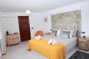 EsteponaLa Pina Verde的一间卧室配有一张带毛巾的黄色毯子