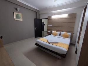 海得拉巴Luxor Park Service Apartment的卧室配有一张带黄色枕头的大型白色床。