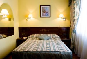 马德里Hostal Centro Sol Madrid的卧室配有一张床,墙上配有两盏灯。