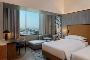 迪拜迪拜阿联酋购物中心喜来登酒店的配有一张床和一张书桌的酒店客房