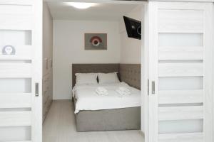 苏恰瓦Exclusive Ultracentral Apartments and Studios #Enescu#Universitatii#Suceava的卧室配有白色墙壁的床