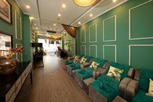 胡志明市Vintage Boutique Hotel & Spa的客厅设有绿色的墙壁和沙发。