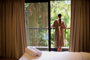 阿伯来Etereo Stays, Luxury Premium Apartments, Arpora, Goa的穿着衣服的女人,从窗户望出去