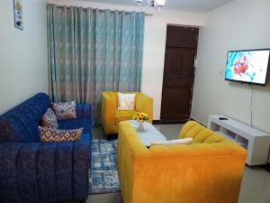 Kitengela Mellow Homes 1 & 2 Bedrooms fully furnished Apartment的客厅配有两张沙发和一台电视机