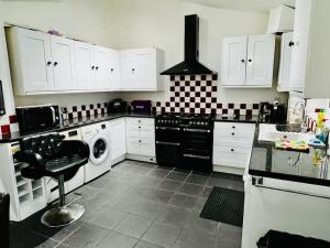 WykenModern & Cozy 3 Bed House.的厨房配有白色橱柜和炉灶烤箱。