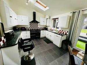 WykenModern & Cozy 3 Bed House.的厨房配有白色橱柜和黑色家电