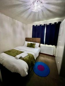 WykenModern & Cozy 3 Bed House.的一间卧室配有两张床、吊灯和蓝色地毯。