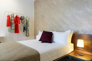 卡萨诺德莱穆尔杰VILLA GENTILE RESORT E SPA的一张带白色床单和红色枕头的床