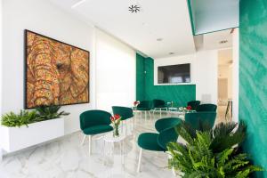 卡萨诺德莱穆尔杰VILLA GENTILE RESORT E SPA的一间设有绿色椅子和墙上一幅大画的等候室