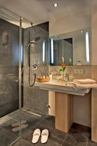 宾茨Suite Hotel Binz Familienhotel Rügen klimaneutral的带淋浴、盥洗盆和镜子的浴室