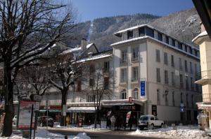 巴涅尔-德吕雄L'Isard, T2, centre Luchon, wifi, ascenseur, casier à ski, 4 personnes的一座城市街道上的建筑,地面上积雪