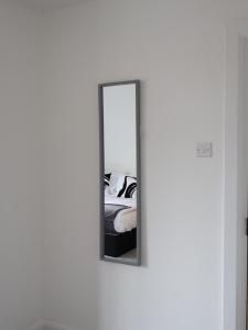 圣奥尔本斯Alban Suites的一面墙上的镜子,床边