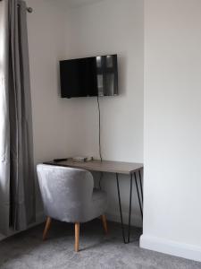 圣奥尔本斯Alban Suites的一张桌子、椅子和墙上的电视
