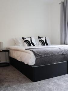 圣奥尔本斯Alban Suites的一张带黑白枕头的床