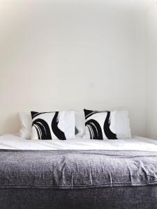 圣奥尔本斯Alban Suites的一张带黑白枕头的床