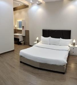 塔伊夫منتجع الكناري للفلل الفندقية الفاخرة Canary resort的一间带白色大床的卧室和一间浴室