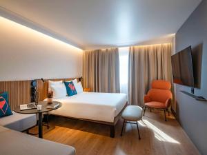 尼斯诺富特尼斯阿里纳斯阿罗伯特酒店的酒店客房设有一张大床和一张书桌。
