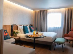 尼斯诺富特尼斯阿里纳斯阿罗伯特酒店的一间酒店客房,配有一张床和一盘食物