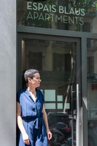 巴塞罗那伊斯帕布劳思公寓的站在商店前身穿蓝色衣服的女人