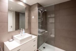 巴塞罗那伊斯帕布劳思公寓的一间带水槽、淋浴和镜子的浴室