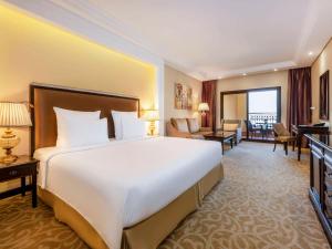 拉斯阿尔卡麦Pullman Resort Al Marjan Island的酒店客房设有一张大床和一间客厅。