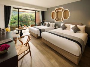 卡伦海滩Avista Grande Phuket Karon - MGallery的酒店客房设有两张床和一个阳台。
