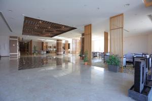 利雅德Dar Hashim Hotel Suites - Alnuzha的大楼里一个带桌椅的空的大堂