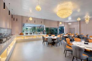 昆明昆明空港经济区戴斯精选温德姆酒店的一间带桌椅的餐厅和一间厨房