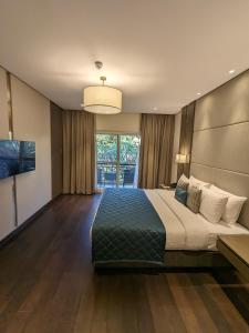 班加罗尔Palm Meadows Resort的一间卧室设有一张大床和一个大窗户