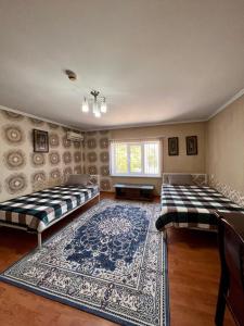 奇姆肯特InJoy hostel的配有地毯的客房内的两张床