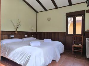鲁比罗德莫拉Masia Del Cura的一间卧室设有两张带白色床单的床和窗户。