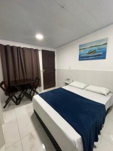 卡波布里奥suites com cozinha compacta的一间卧室配有一张大床和一把椅子