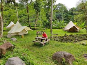 沙马林达Borneo camp的坐在帐篷前野餐桌上的人