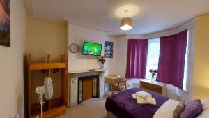 查塔姆Cosy Villa- 5 Bedroom Accommodation Great For Longer Stays!!!的一间卧室配有一张床、一台电视和一个壁炉
