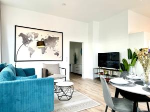 格尔斯托芬E&K living - city central - design apartment - kitchen - free parking的客厅配有蓝色的沙发和桌子