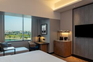迪拜迪拜阿联酋购物中心喜来登酒店的配有一张床和一台平面电视的酒店客房