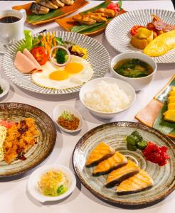 曼谷Hotel JAL City Bangkok的盛满食物和碗的桌子