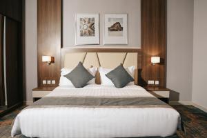 阿可贺巴Dream Residence Rawabi-دريم رزيدنس الروابي的卧室配有带枕头的大型白色床