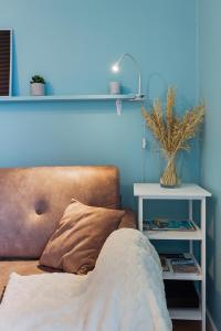 南特Joli studio - Parking Privé - WIFI Très Haut Débit - Au calme的蓝色的房间,配有沙发和桌子,种植了植物