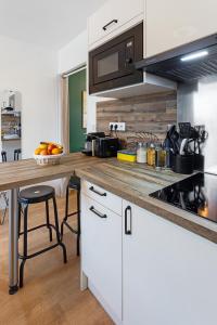 南特Joli studio - Parking Privé - WIFI Très Haut Débit - Au calme的厨房配有白色橱柜和木制台面