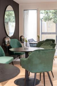 霍恩埃姆斯Village by Maier - kontaktloser Check-in的配有绿色椅子、桌子和镜子的房间