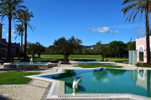 辛特拉辛特拉佩斯塔纳高尔夫SPA度假酒店的棕榈树庭院内的游泳池