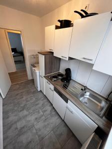 埃内佩塔尔Tolle Monteursunterkunft für 6 Personen的小厨房配有白色橱柜和水槽