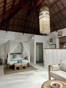 San IsidroYapak Beach Villas的一间卧室配有一张床、一张沙发和一个吊灯。