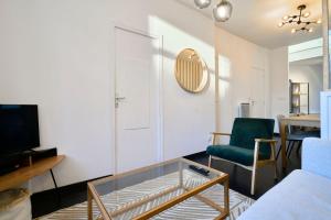 图尔昆Renovated 3 bedroom house with terrace的客厅配有玻璃咖啡桌和绿色椅子