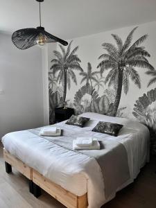 克莱蒙费朗Le Loly的卧室配有一张大床,墙上挂着棕榈树